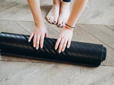 Minimalist yoga equipment on a dark floor